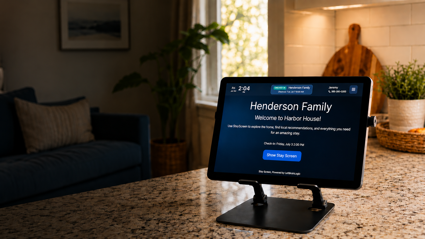 StayScreen tablet displaying a personalized guest welcome screen in a vacation rental kitchen